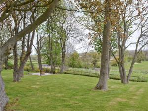 un parque con árboles y césped y una valla en John Wesley Cottage en West Kyo