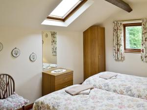 a bedroom with two beds and a dresser and a window at Harebell Hill Jericho Farm in Earl Sterndale