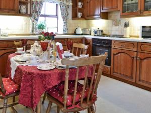 a kitchen with a table with a red table cloth at Primrose Cottage - Lpg in Ireby