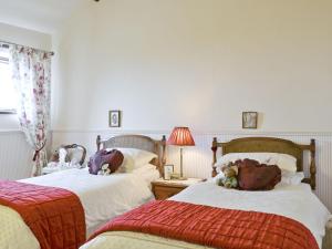 a bedroom with two beds with stuffed animals on them at Primrose Cottage - Lpg in Ireby