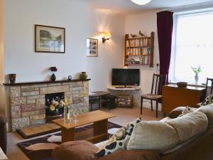 a living room with a couch and a fireplace at Broadstone Cottage in Norham