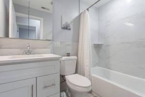 uma casa de banho branca com um WC, um lavatório e uma banheira em Brand New Dbl Unit Roofdeck Outdoor Patio em Filadélfia