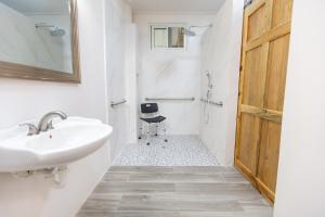 La salle de bains blanche est pourvue d'un lavabo et d'un miroir. dans l'établissement Sea Eye Hotel - Laguna Building, à Utila