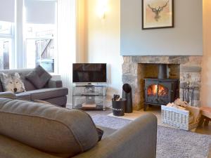 a living room with a couch and a fireplace at Dovecote House in Wooler