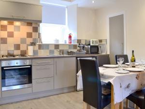 a kitchen with a table and a kitchen with a table and chairs at Dovecote House in Wooler