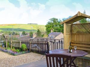 a patio with a table and a wooden fence at Dovecote House in Wooler