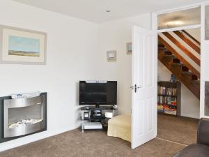 a living room with a television and a staircase at Roanne - E5348a in Belton