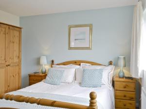 a bedroom with a bed with white sheets and blue pillows at Roanne - E5348a in Belton