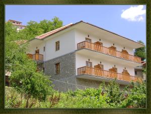 a white house with balconies on the side of it at HOTEL MARI Metsovo in Metsovo
