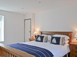 a bedroom with a bed with blue and white pillows at Tides in Cromarty