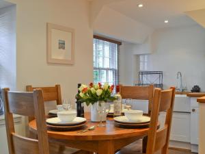 a dining room table with plates and flowers on it at Tides in Cromarty