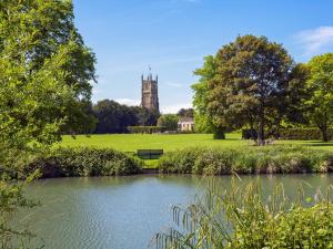 a view of a pond in a park with a clock tower at Apartment 3 in South Cerney