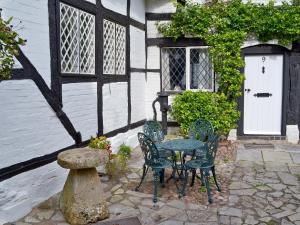 a table and chairs in front of a house at Hathaway Hamlet in Stratford-upon-Avon