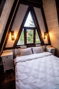 a large bed in a room with a large window at Camere de închiriat Pași Liberi in Tău Bistra