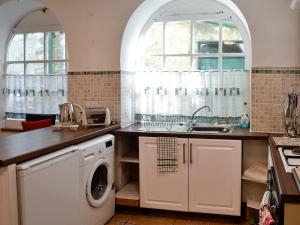 cocina con fregadero y lavadora en Smithy House en Betws-y-coed