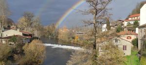 um arco-íris sobre um rio numa cidade em Apartamento Portovello con vistas al río em Allariz