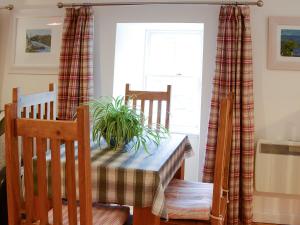 a dining room table with a potted plant on it at The Cottage in Rispond