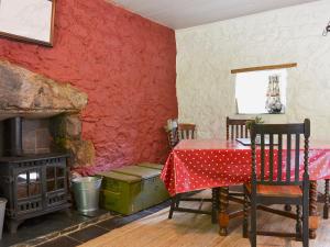 a dining room with a table and a fireplace at Old Mill Cottage in Acharra
