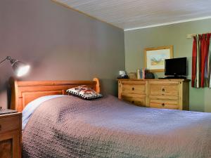 a bedroom with a bed and a dresser at Old Mill Cottage in Acharra