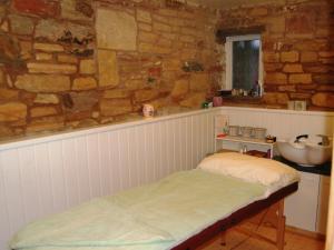 1 dormitorio con 1 cama y lavamanos en una pared de piedra en The Bird Bath, en Wreay