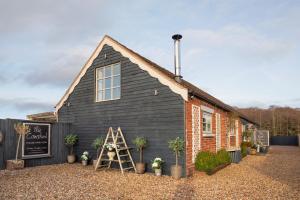 a black building with a sign in front of it at The Cowshed at Cheshire Boutique Barns in Nantwich