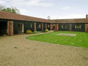 a house with a large yard in front of it at Beech Barn in Horning