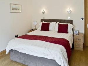 1 dormitorio con 1 cama grande con almohadas rojas en Low Tide, en Beadnell