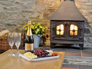 a table with a bottle of champagne and wine glasses at Golygfar Mynydd - Mountain View in Strata Florida