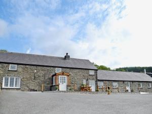 an old stone building with a white door and windows at Golygfar Mynydd - Mountain View in Strata Florida