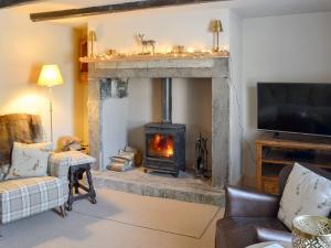 a living room with a fireplace and a stove at West End Cottage in Whittingham