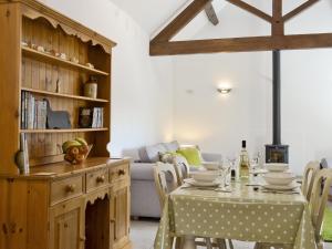 a dining room with a table and a couch at Apple Cottage in Culmington