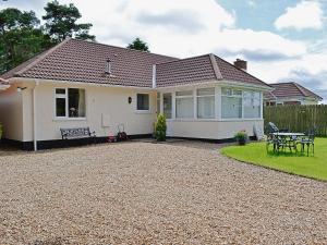 a house with a gravel driveway in front of it at South Cleeve Bungalow in Otterford