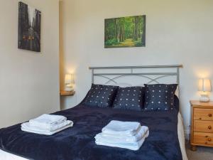 a bedroom with a bed with blue sheets and pillows at Parkview in Skipton