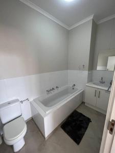 une salle de bains avec baignoire, toilettes et lavabo dans l'établissement Beachfront apartment, au Cap 6 autres photos