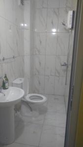 a white bathroom with a toilet and a sink at Çiftlik otel 