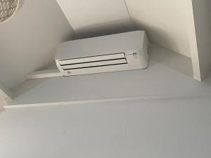 a white air conditioner sitting on a shelf in a room at Lise's Place in Vrouwenpolder
