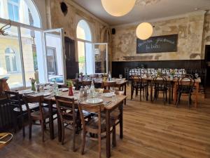 a restaurant with wooden tables and chairs and windows at Storyhotel Bergischer Hof Königswinter in Königswinter