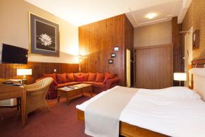 um quarto de hotel com uma cama e um sofá em Hotel Dordrecht em Dordrecht