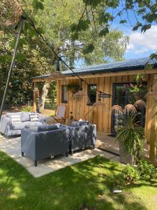 un patio con divani e sedie in un cortile di Meadows Lodge a York