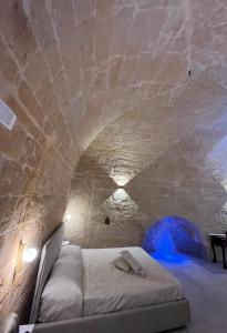 a room with a bed in a stone tunnel at Lo scorcio sul Barisano in Matera
