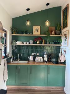 een keuken met blauwe kasten en groene muren bij Meadows Lodge in York