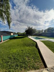 un patio de césped con una acera junto a una piscina en Quebracho blanco en Bialet Massé