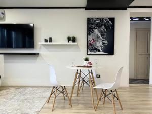 a dining room with a white table and chairs at Апартаменты LUX + in Pavlodar