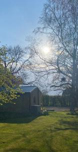 a barn in a field with the sun in the background at Meadows Lodge in York