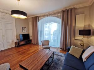 ein Wohnzimmer mit einem blauen Sofa und einem Tisch in der Unterkunft Le Royal Couëdic - Les Maisons de Madeleine in Nantes