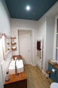uma casa de banho branca com um lavatório e um chuveiro em Le Royal Couëdic - Les Maisons de Madeleine em Nantes