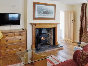 a living room with a fireplace and a tv at Porters Lodge in Glyn-Dyfrdwy