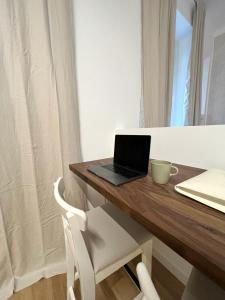 un computer portatile seduto sopra una scrivania in legno di Divini Gae Aulenti a Milano