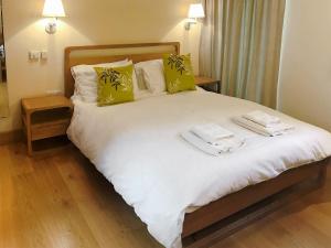 1 dormitorio con 1 cama con almohadas verdes y blancas en Red House Farm Cottage en Whitegate