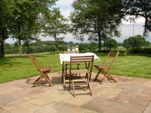 una mesa y sillas con copas de vino en Red House Farm Cottage en Whitegate